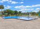 Community pool with a water view, lounge chairs, and tropical landscaping under a beautiful blue sky at 11 Escondido Cir # 110, Altamonte Springs, FL 32701