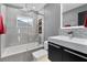 This bathroom suite has a shower-tub combination, modern tiling and decor, and black vanity at 116 Alcala Dr, Kissimmee, FL 34758