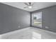 Simple bedroom with tile flooring, ceiling fan, and a window providing natural light at 116 Alcala Dr, Kissimmee, FL 34758