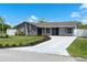 Charming single-story home featuring fresh landscaping, a long concrete driveway, and a freshly painted exterior at 116 Alcala Dr, Kissimmee, FL 34758