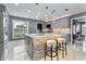 Modern kitchen featuring gray cabinets, quartz countertops, a stone-accented island with bar seating, and stainless appliances at 116 Alcala Dr, Kissimmee, FL 34758