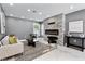 Modern living room with a stone accent wall, electric fireplace, recessed lighting, and stylish decor at 116 Alcala Dr, Kissimmee, FL 34758