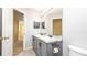 Bathroom featuring double sinks, marble countertop, gray cabinetry, and large mirror at 1204 Blackheath Ct, Davenport, FL 33897