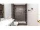 Modern bathroom featuring dark tile shower, sleek fixtures and recessed niche at 1204 Blackheath Ct, Davenport, FL 33897