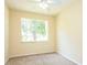 Cozy carpeted bedroom with neutral paint, a ceiling fan, and a large window at 1204 Blackheath Ct, Davenport, FL 33897