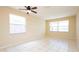 Sunny bedroom with tiled floor, two windows, neutral paint, and bright, natural light at 1204 Blackheath Ct, Davenport, FL 33897