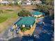 Overhead view of the clubhouse with a green roof, golf carts, and ample parking at 1204 Blackheath Ct, Davenport, FL 33897