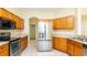 Spacious kitchen featuring stainless steel appliances, wood cabinets, and bright tile flooring at 1204 Blackheath Ct, Davenport, FL 33897