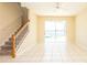 Bright living room with tiled floor, stairs, and sliding glass doors to the outdoor pool area at 1204 Blackheath Ct, Davenport, FL 33897