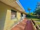 Exterior view of the home with a brick walkway, palm tree and yellow siding at 1221 Oak Haven Dr, Altamonte Springs, FL 32714