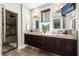 Elegant bathroom with dual sinks, granite countertop, walk-in shower, and a view of a custom closet at 13 Hill Ave, Orlando, FL 32801