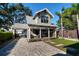 Charming two-story home with a covered front porch and a beautifully paved driveway at 13 Hill Ave, Orlando, FL 32801