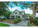 Daytime view of a two-story home featuring a brick paved driveway and mature trees at 13 Hill Ave, Orlando, FL 32801