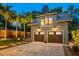 A detached two-car garage boasts an upper level and a charming brick paver driveway and fire pit area at 13 Hill Ave, Orlando, FL 32801