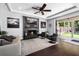 Elegant living room with a modern fireplace, ceiling fan, and access to the patio at 13 Hill Ave, Orlando, FL 32801