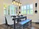 Sunlit dining area with elegant chandelier, seating, and views of the landscaped exterior at 15707 Cutter Sail Pl, Winter Garden, FL 34787