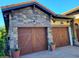 Two-car garage with stone accents and lush landscaping at 15707 Cutter Sail Pl, Winter Garden, FL 34787
