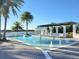 Resort-style pool with water features, lounge chairs, and a beautiful lake view at 15707 Cutter Sail Pl, Winter Garden, FL 34787