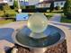 Community water feature featuring a round reflective sculpture over a wide basin with blue bench at 15707 Cutter Sail Pl, Winter Garden, FL 34787