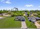 An aerial view of a single-story house featuring a well-kept lawn and paved driveway at 15823 Sw 27Th Avenue Rd, Ocala, FL 34473