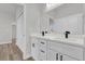 Bright bathroom featuring double sinks with modern black fixtures, white cabinets, and a large mirror at 15823 Sw 27Th Avenue Rd, Ocala, FL 34473