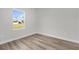 This bedroom features wood-look floors and a view of the property through a large window at 15823 Sw 27Th Avenue Rd, Ocala, FL 34473
