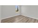 This bedroom features wood-look floors and a bright window that looks out to the property at 15823 Sw 27Th Avenue Rd, Ocala, FL 34473