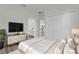 A modern bedroom with a plush bed, a large TV on a stylish dresser, and access to the bathroom and kitchen at 15823 Sw 27Th Avenue Rd, Ocala, FL 34473
