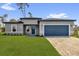 Beautiful home featuring a two-car garage, blue door, and freshly manicured lawn at 15823 Sw 27Th Avenue Rd, Ocala, FL 34473