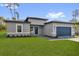 Single story home with a two-car garage, manicured lawn, and paver driveway at 15823 Sw 27Th Avenue Rd, Ocala, FL 34473