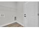 Laundry room with white door, wire shelving, washer hookups, and wood-look flooring at 15823 Sw 27Th Avenue Rd, Ocala, FL 34473