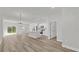 Bright, open-concept living space with modern wood-look floors, white kitchen, and abundant natural light at 15823 Sw 27Th Avenue Rd, Ocala, FL 34473