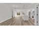 Open-concept living space with modern wood-look floors, white kitchen island, and abundant natural light at 15823 Sw 27Th Avenue Rd, Ocala, FL 34473