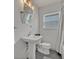 Simple and clean bathroom with a pedestal sink, neutral color palette, and natural light at 1661 Woodland Ave, Winter Park, FL 32789