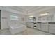 Bright bathroom with dual vanities, modern fixtures, a soaking tub and large mirrors at 1661 Woodland Ave, Winter Park, FL 32789