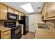 Efficient kitchen featuring black appliances, wood-look flooring and good counter space at 1728 Townhall Ln # 1728, Orlando, FL 32807