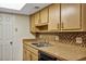 Kitchen featuring tan countertops and cabinetry, a stainless sink, and tiled backsplash at 1728 Townhall Ln # 1728, Orlando, FL 32807