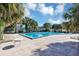 Large community pool surrounded by palm trees and lounge chairs on a sunny day at 1728 Townhall Ln # 1728, Orlando, FL 32807