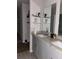 Bathroom with double sinks, granite countertop, and a large mirror, with tile flooring and grey cabinets at 17333 Cagan Crossings Blvd, Clermont, FL 34714