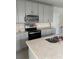 Kitchen with granite counters, stainless steel oven/microwave, and gray cabinets, with a sink at 17333 Cagan Crossings Blvd, Clermont, FL 34714