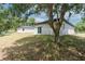Exterior of home featuring a backyard with sliding glass doors and tree at 1819 Carr St, Deland, FL 32720