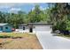 Inviting single-story home with a two-car garage and a long driveway, surrounded by lush trees at 1819 Carr St, Deland, FL 32720