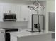 Modern kitchen featuring white cabinetry, stainless steel appliances, and a stylish island with marble counters at 1819 Carr St, Deland, FL 32720