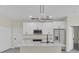 Modern kitchen features white cabinetry, a stylish lighting fixture, and stainless appliances at 1819 Carr St, Deland, FL 32720