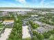 Wide aerial view of a residential area surrounded by lush greenery, a lake, and various community buildings at 1845 Common Way Rd # 28-206, Orlando, FL 32814