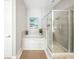 Bright bathroom with large tub and glass enclosed shower at 1845 Common Way Rd # 28-206, Orlando, FL 32814