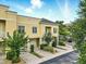 Charming yellow townhome featuring individual garages, a balcony, and well-manicured landscaping at 1845 Common Way Rd # 28-206, Orlando, FL 32814