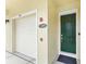 Inviting entryway features a green door, a white garage door, and unit number 206, with a beige exterior at 1845 Common Way Rd # 28-206, Orlando, FL 32814