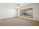 Bright bedroom with plush carpet, ceiling fan, and natural light from a large window at 1889 Eden Dr, Deltona, FL 32725