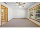 Bright bedroom with plush carpet, ceiling fan, and natural light from a large window at 1889 Eden Dr, Deltona, FL 32725